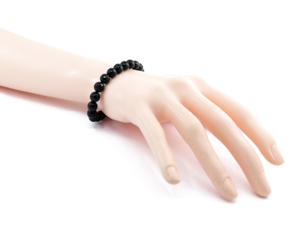 Bracelet tourmaline schorl avec perles noires facettées porté sur une main