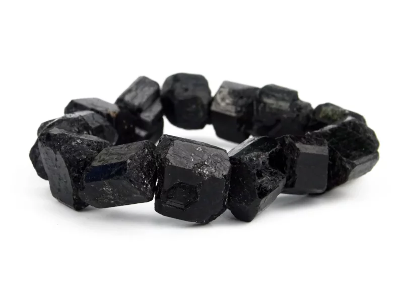 Black tourmaline (schorl) bracelet with rough black natural stones, close-up front view on a white background