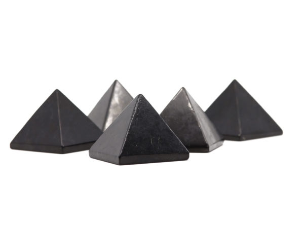 Pyramides en shungite avec différents dessins de pierre naturelle sombre en vue groupée