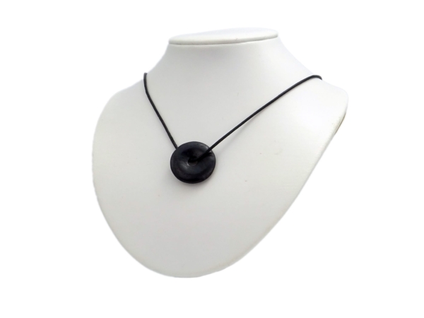 Pendentif donut en shungite sur collier noir en vue portée sur un buste de présentation blanc