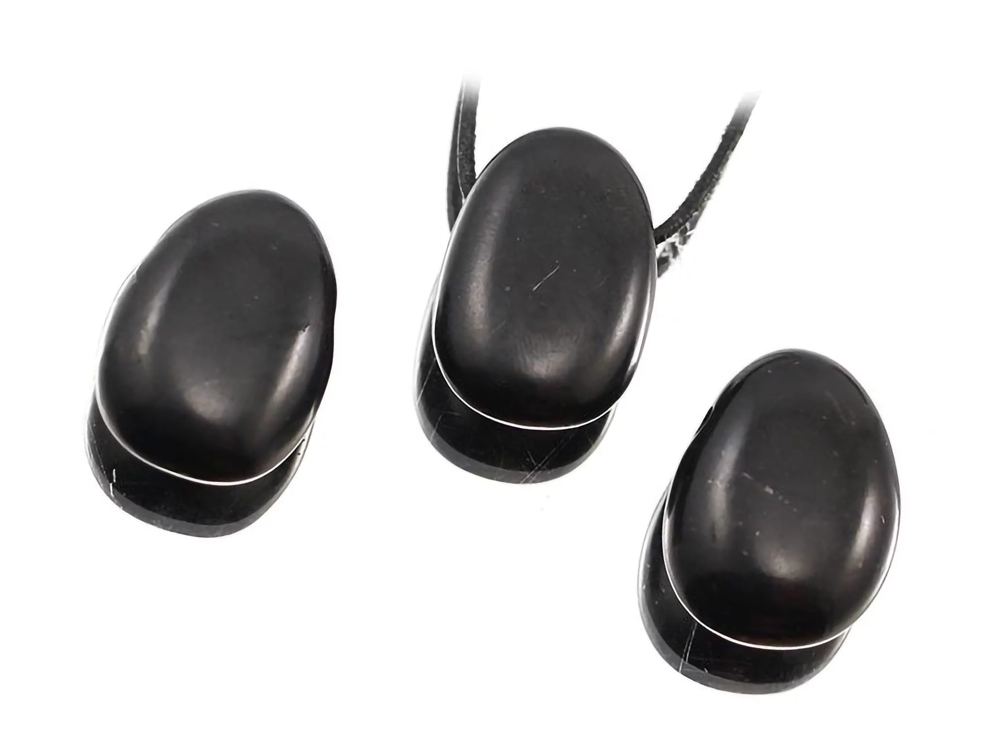 Pendentif pierre trouée en shungite à côté d'autres variantes de pierres naturelles noires en vue détaillée