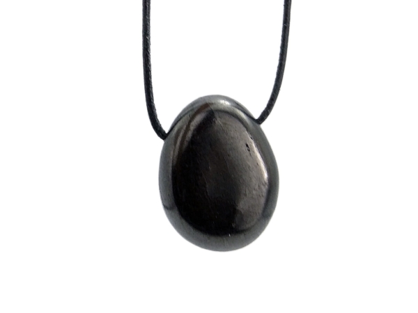 Pendentif pierre trouée en shungite avec surface noire brillante polie en vue rapprochée