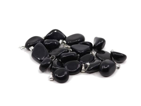 Sélection de pendentifs en pierre précieuse obsidienne noire parmi de nombreuses pierres noires polies lisses