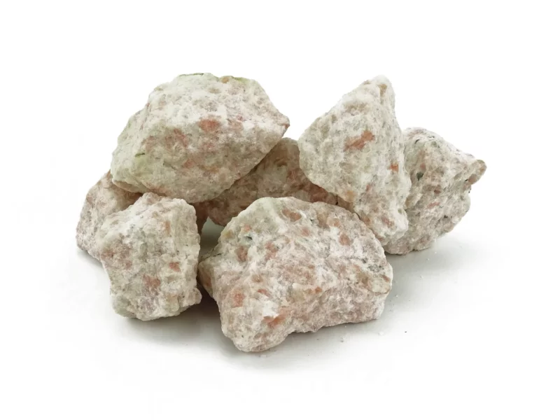 Sunstone water stones as irregular rough stones with pink inclusions on a white background