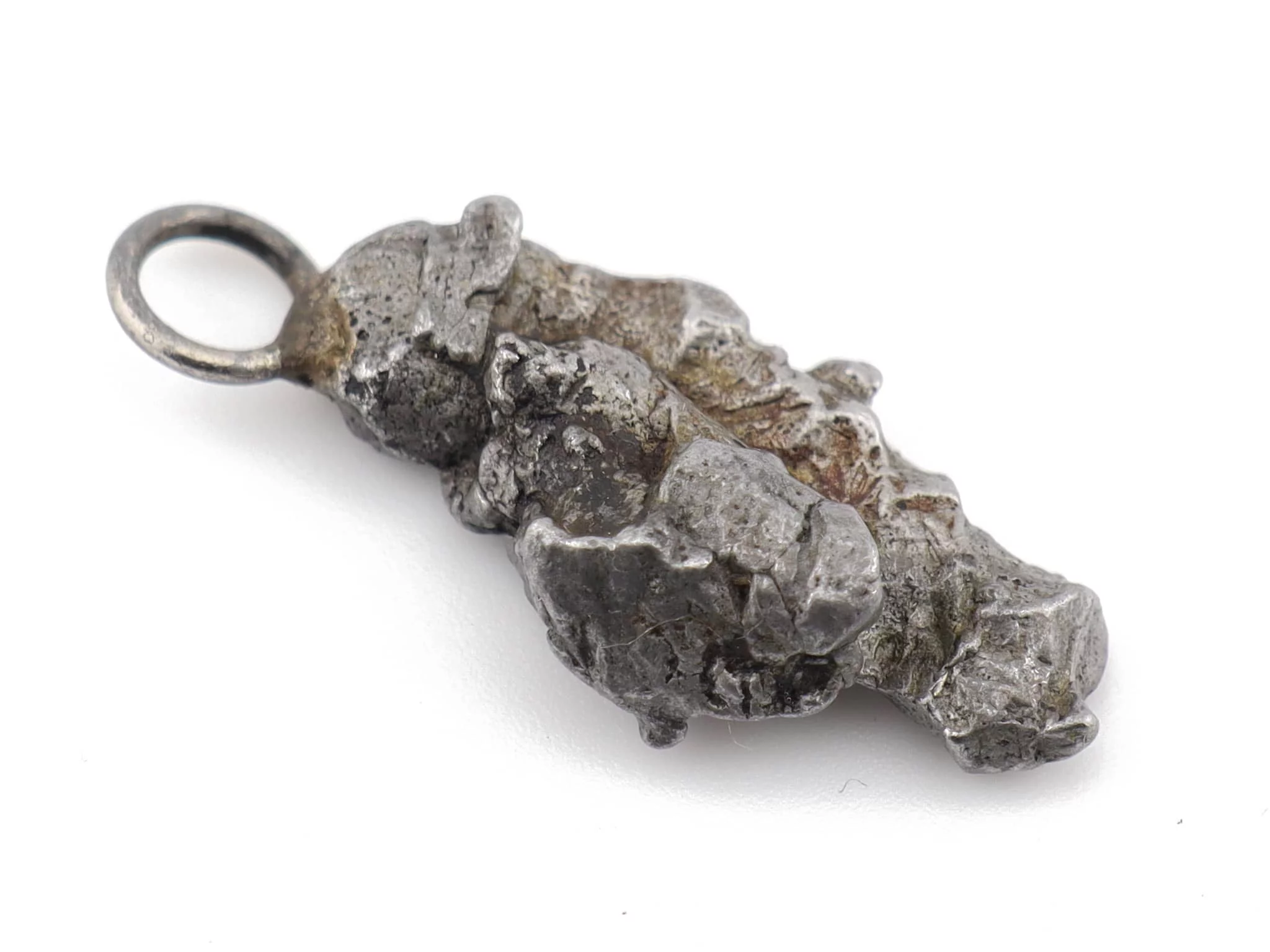 Pendentif en météorite Campo del Cielo, vue rapprochée de côté avec surface métallique rugueuse