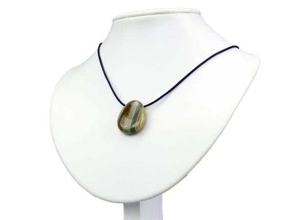 Pendentif en jaspe rayé comme collier sur buste à bijoux blanc avec cordon noir