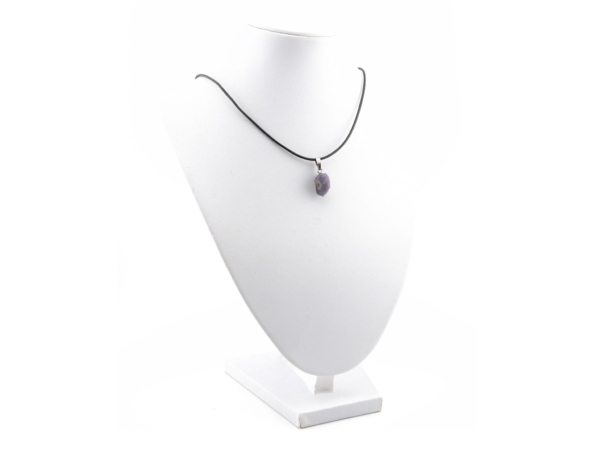 Raw tanzanite pendant on a black necklace on a white jewellery bust