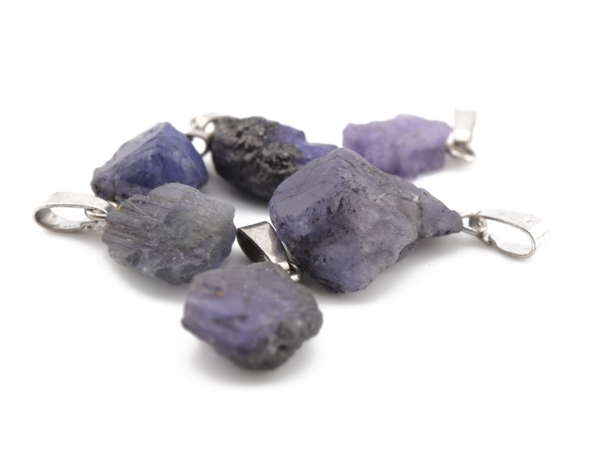 Raw tanzanite pendants in various blue-violet shapes with silver bails