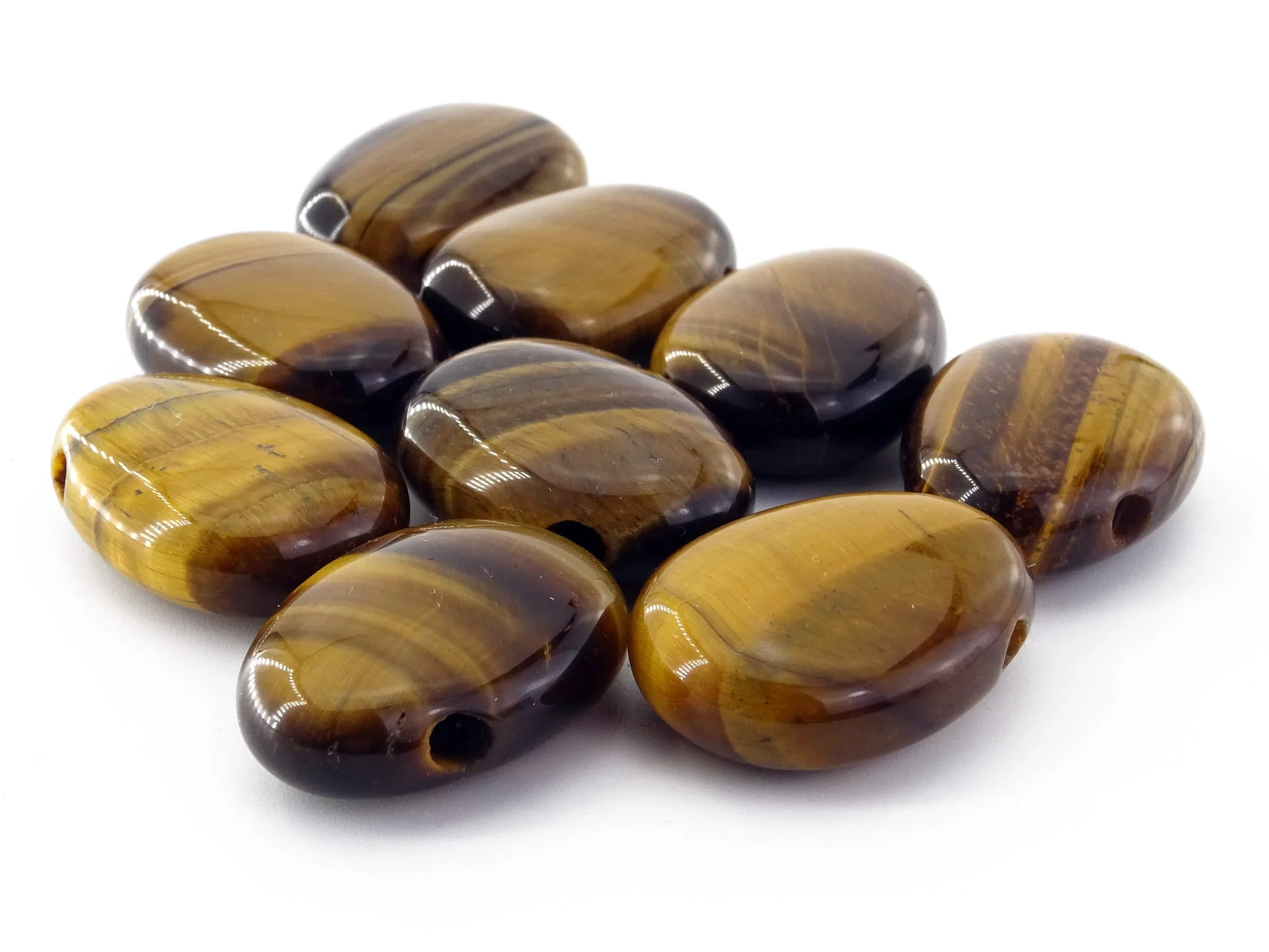 Tiger's eye gemstone pendant selection of several polished drilled stones on a white background