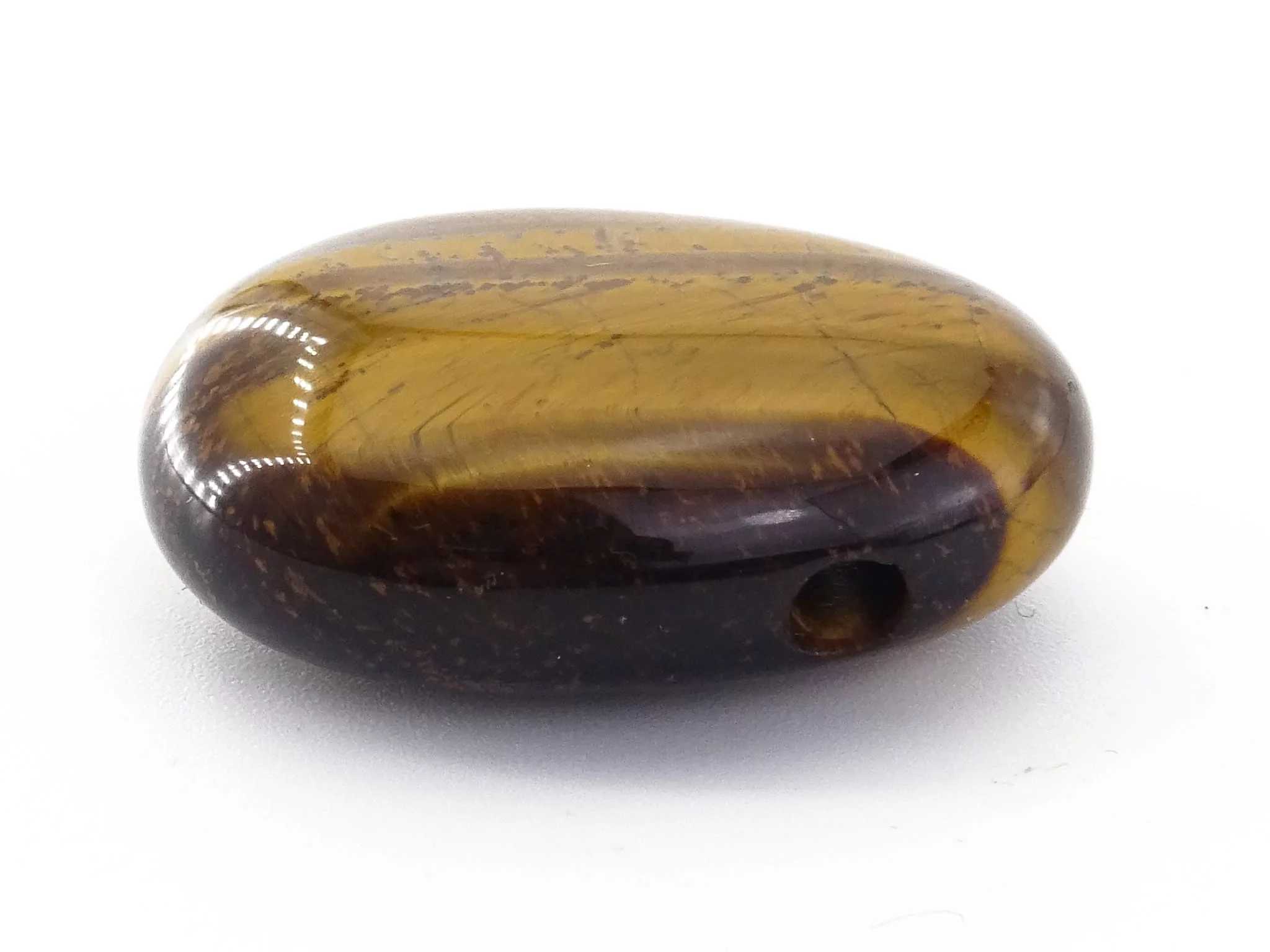 Side view of tiger's eye gemstone pendant showing the drilled hole in the polished stone