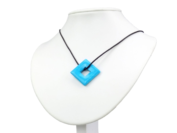 Turkenite square donut pendant worn on a black necklace on a white bust