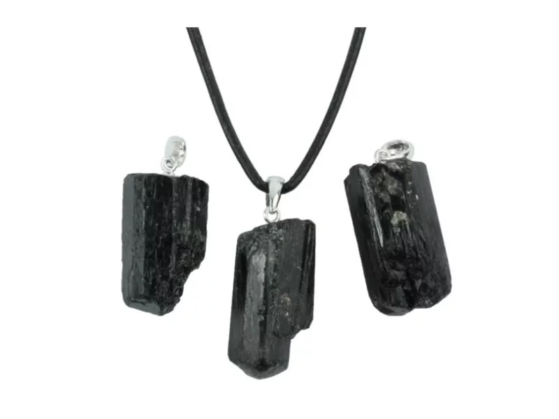 Black tourmaline schorl raw stone pendant with silver bail and black necklace on white background