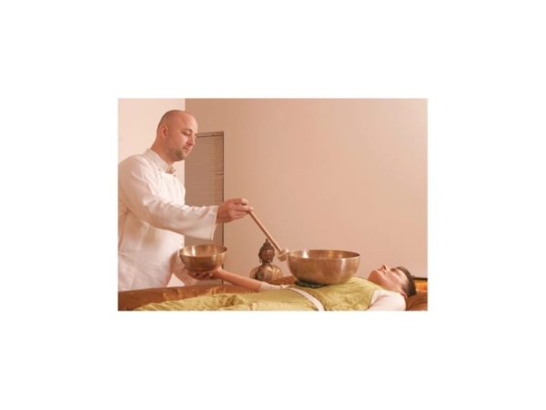 Peter Hess Small Heart Bowl during a sound massage, with mallet above a lying person